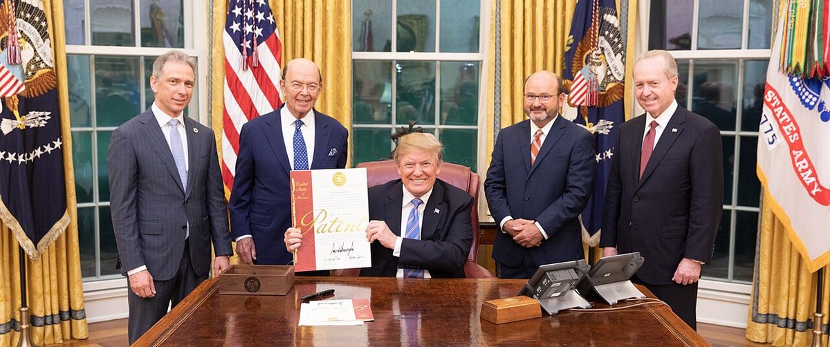 Donald Trump holding up the 10 millionth US patent with his signature